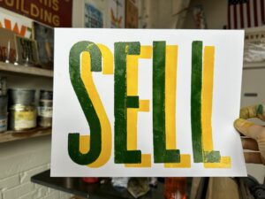 A sign that says "SELL" in green and gold.