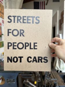 A poster that says "Streets for people not cars"