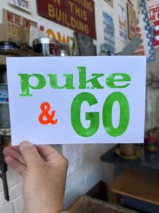 A hand holding a card that says "puke & GO"